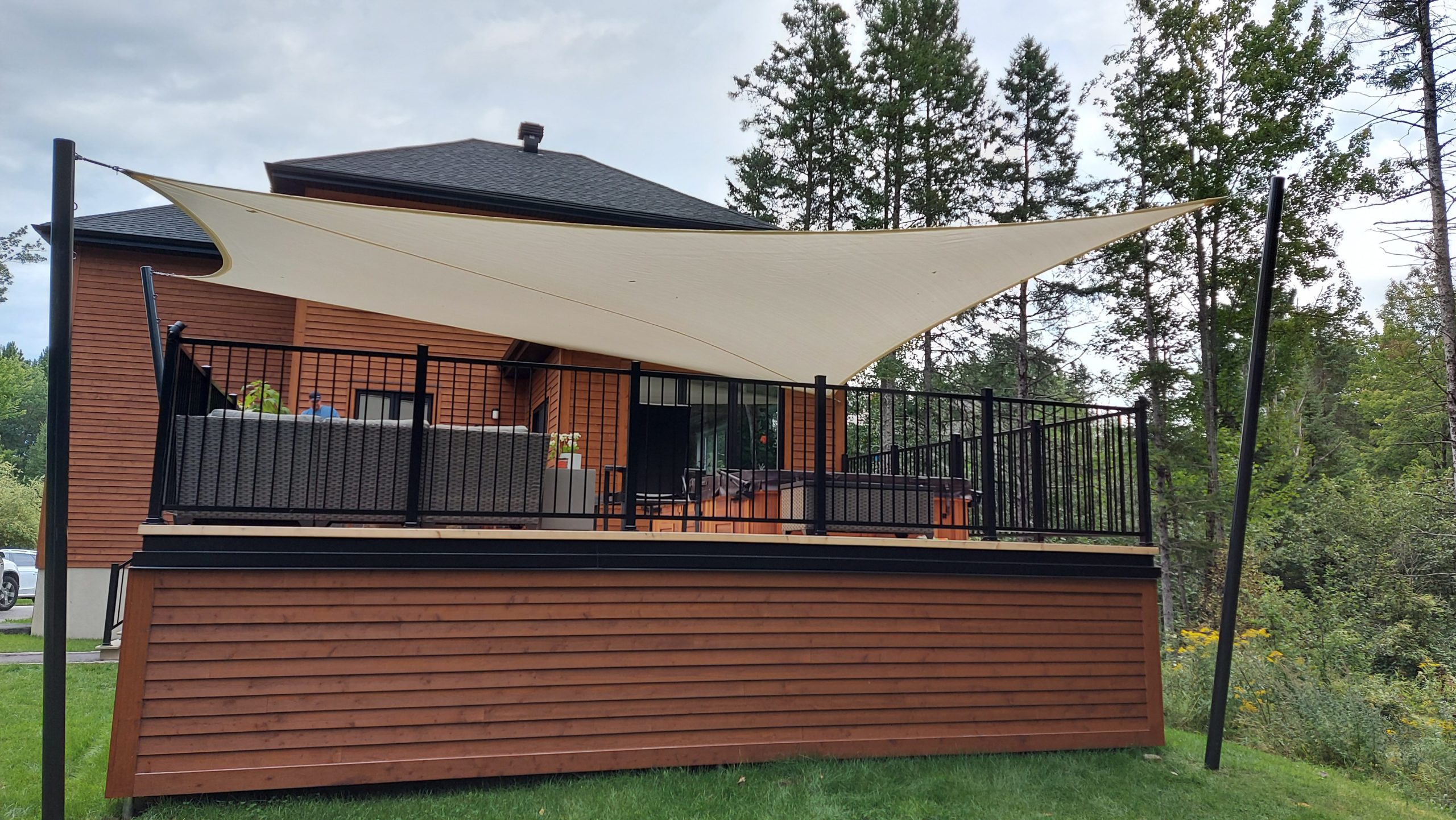 Beige shade sail shading a backyard patio and dining set in an Ontario home