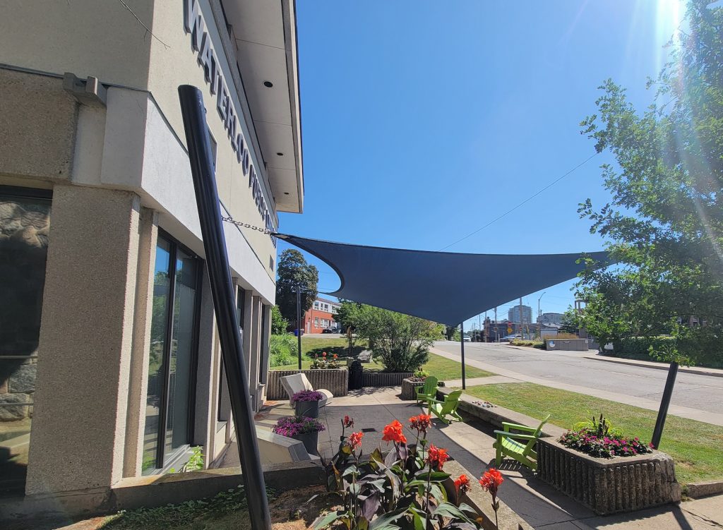 20250718_110430 Navy shade sail over Waterloo Public Library outdoor space Ontario